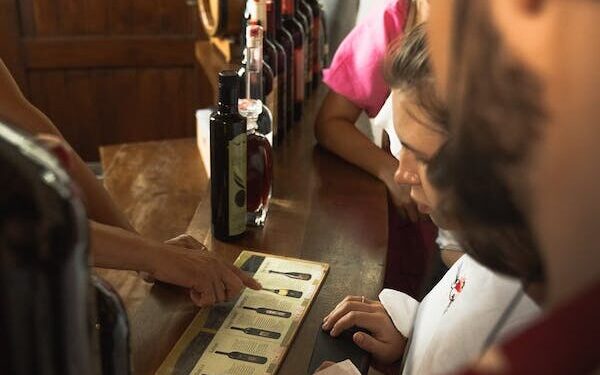Menschen bei einer Weinverkostung https://www.pexels.com/de-de/foto/menu-menschen-zeigen-kunde-8765700/